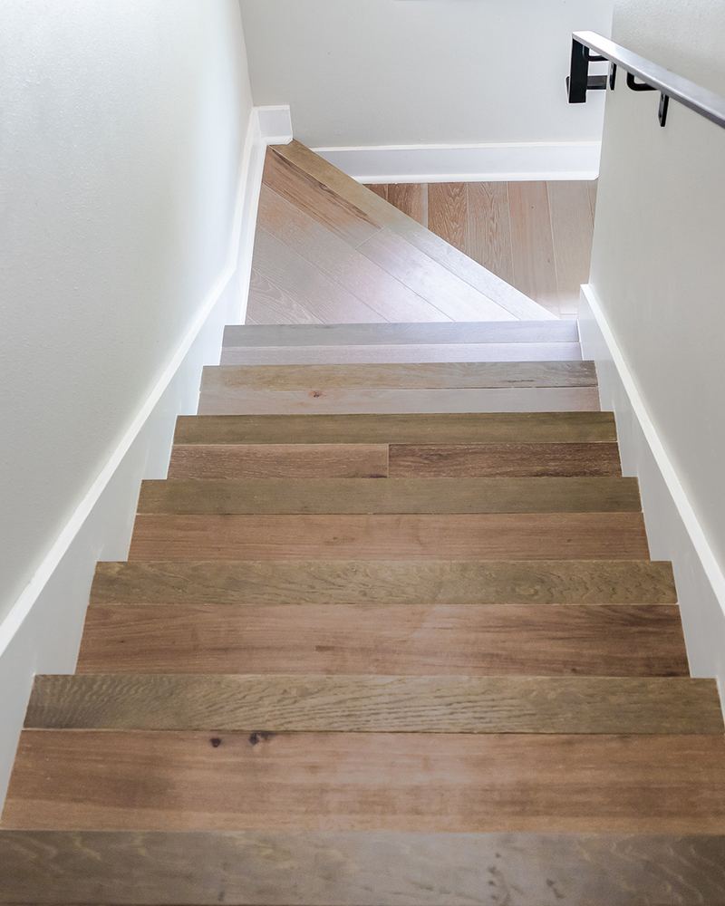 Houten traptreden met een strakke witte trapwand