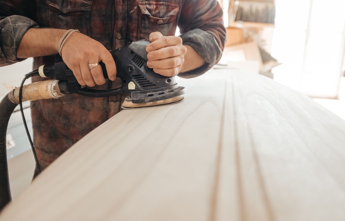 Timmerman schuurt een houten plank glad